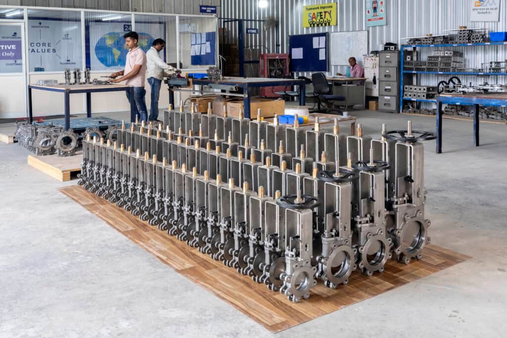 Industrial knife gate valves assembled in a modern manufacturing facility, showcasing stainless steel valves for wastewater, slurry, mining, chemical, and process industries.